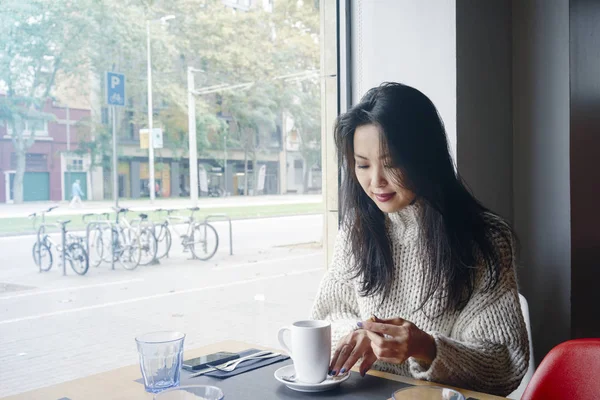 年轻漂亮的女学生在咖啡馆里喝咖啡 有吸引力的女孩喝咖啡在一个城市背景的咖啡馆里 — 图库照片
