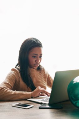 Kafede dizüstü bilgisayarda yazarak çekici bir Afrikalı-Amerikalı kadın portresi