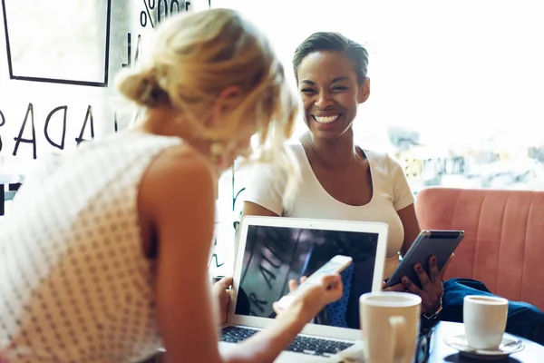 Duas Mulheres Bonitas Sentadas Café Usando Dispositivos Eletrônicos Enquanto Fazem — Fotografia de Stock