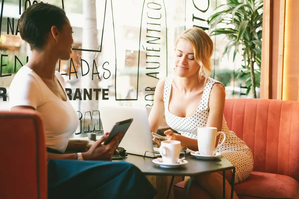 Två Vackra Kvinnor Sitter Café Använder Elektroniska Apparater Samtidigt Kaffepaus — Stockfoto