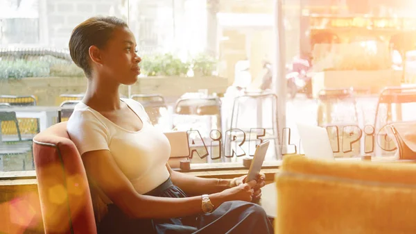 Kaunis Afrikkalainen Liikenainen Istuu Digitaalinen Tabletti Kädessään Kahvilassa — kuvapankkivalokuva