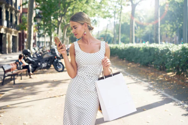 Mulher Loira Bonita Com Sacos Papel Branco Smartphone Andando Rua — Fotografia de Stock