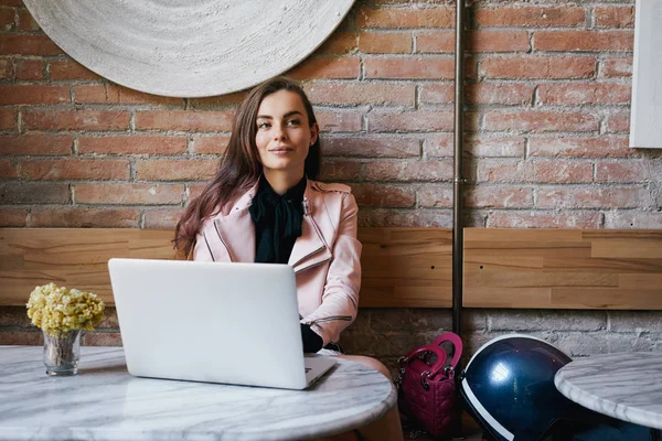 Młoda Kobieta Różowy Skórzaną Kurtkę Pomocą Laptopa Kawiarni — Zdjęcie stockowe