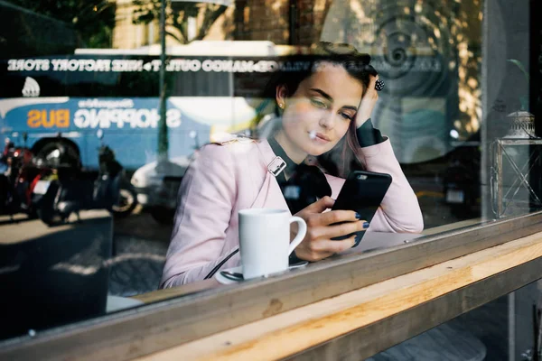 Молодой Студент Набирает Текстовое Сообщение Современном Смартфоне Пока Пьет Кофе — стоковое фото