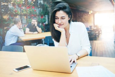 Güzel genç işkadını bir kafede otururken öğle yemeği molası sırasında laptop ile çalışma 