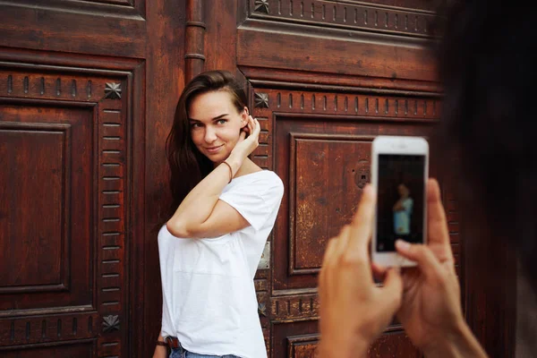 Mujer Joven Posando Contra Puerta Madera Mientras Amigo Está Tomando — Foto de Stock