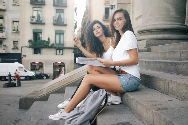 Two Young Women Taking Pictures While Sitting Outdoors Stairs Backpacks — Stock Photo, Image