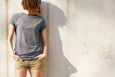 gri boş t-shirt beton duvar arka planı poz giyen güzel genç kadın 