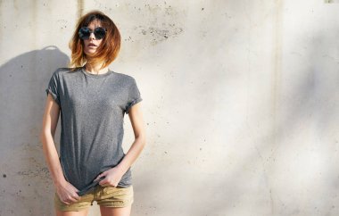 gri boş t-shirt arka plan beton duvara karşı poz giyen güzel genç kadın