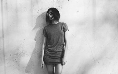 gri boş t-shirt ve arka plan beton duvara karşı poz güneş gözlüğü giyen güzel genç kadın 