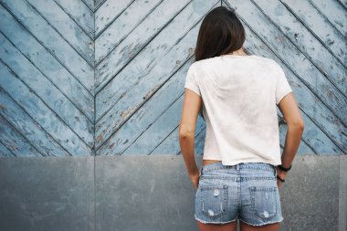hafif mavi ahşap çit karşı bekleyen boş bir beyaz t-shirt güzel genç kadın