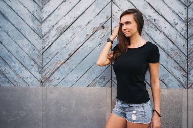 hafif mavi ahşap çit karşı bekleyen boş bir siyah t-shirt güzel genç kadın