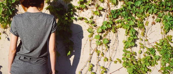 Jonge Vrouw Een Leeg Grijs Shirt Staande Tegen Muur Van — Stockfoto