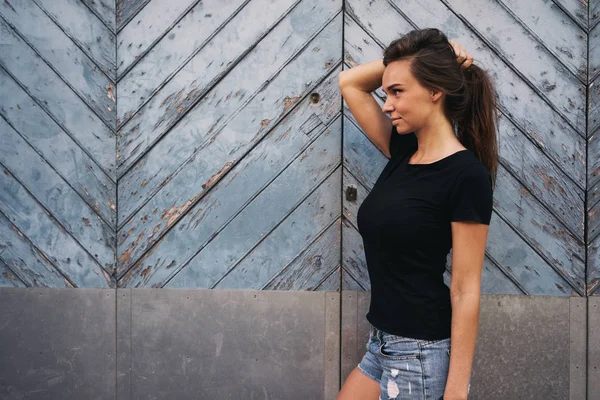 Schöne Junge Frau Einem Schwarzen Shirt Das Vor Einem Hellblauen — Stockfoto