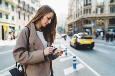 Sokakta yürürken Smartphone kullanarak şık giyim güzel genç kadın