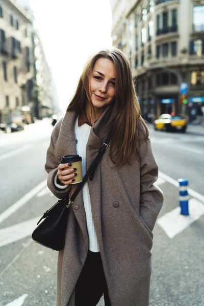 流行のストリート服と保持に身を包んだ美しい若い女性の屋外のポートレートを取るまで手にコーヒー カップ — ストック写真