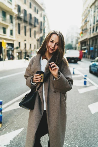 流行のストリート服と保持に身を包んだ美しい若い女性の屋外のポートレートを取るまで手にコーヒー カップ — ストック写真