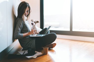 Bir yere oturmak ve dizüstü bilgisayar kullanarak genç kadın 