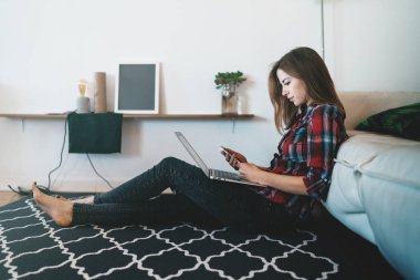 Evde Smartphone ve dizüstü bilgisayar kullanan Modern başarılı kadın