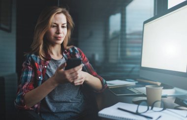 Profesyonel iş kadını ofiste smartphone ve kişisel modern bilgisayar kullanarak 