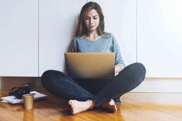 坐在地板上的年轻妇女和使用膝上型电脑 — 图库照片
