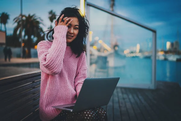 Uśmiechnięta Azjatycka Hipsterka Surfująca Sieci Przenośnym Komputerze Siedząc Przy Miejskim — Zdjęcie stockowe