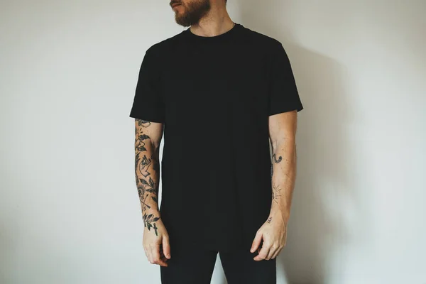 Fiatal Vonzó Férfi Szakállal Tetoválásokkal Fekete Üres Pólóban Fehér Falnak Stock Kép