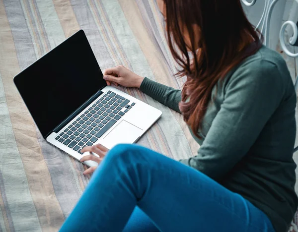 Girl with a laptop on the bed — Stock Photo, Image