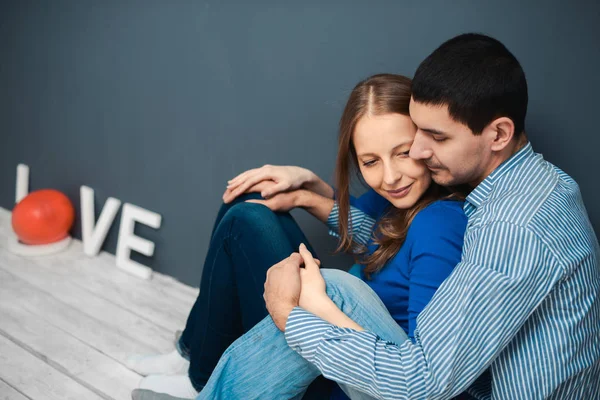 Kärlek paret sitter på golvet i rummet — Stockfoto