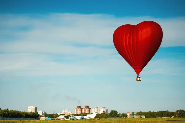 Horkovzdušný balón ve tvaru srdce létání na modré obloze — Stock fotografie