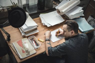 Planları üzerinde çalışan bir erkeğin