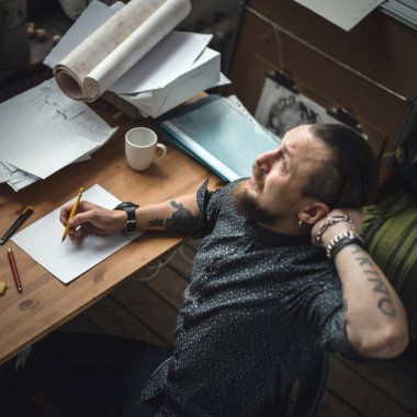 Planları üzerinde çalışan bir erkeğin