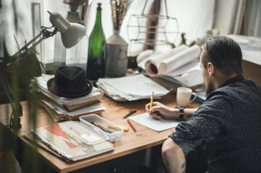 Planları üzerinde çalışan bir erkeğin