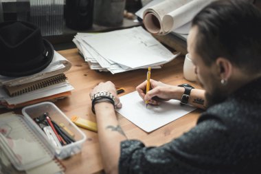 Planları üzerinde çalışan bir erkeğin