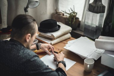 Planları üzerinde çalışan bir erkeğin