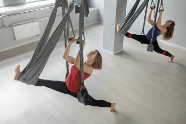 Girls do yoga on hammocks clipart