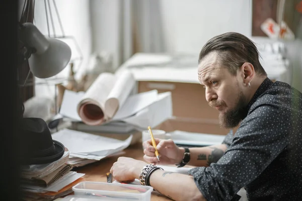 Un hombre trabajando en planos en el arquitecto de oficinas — Foto de Stock