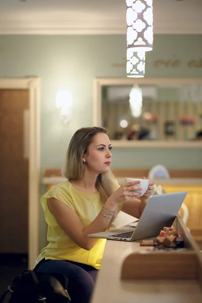 A beautiful girl drinks coffee to a cafe — Stock Photo, Image