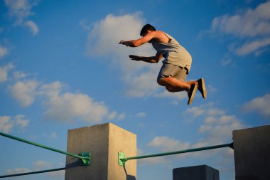 Genç adam parkour duvarlarda atlama