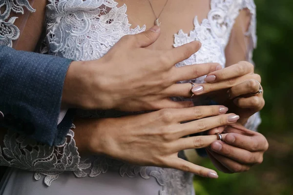 Hands of the bride and groom dress rings