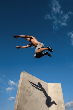 Genç adam parkour duvarlarda atlama