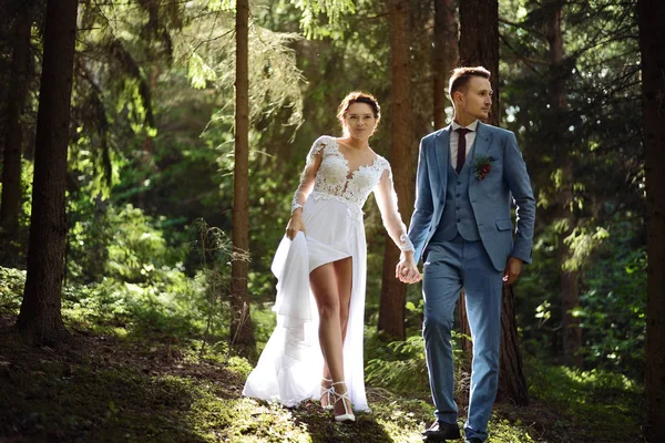 Bride and groom walking in the woods