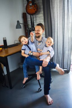 Baba ve oğulları evde oynuyorlar.