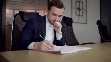 Genç işadamı ofiste oturuyor.