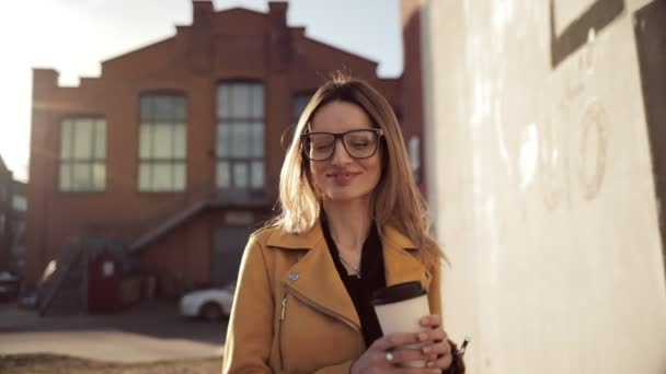 女の子がコーヒーを飲むし 街を歩く — ストック動画