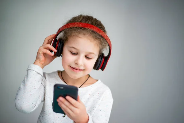 Dziewczynka Czerwonych Słuchawkach Telefonem — Zdjęcie stockowe