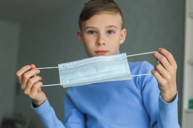 Çocuk koruyucu bir maske takıyor.