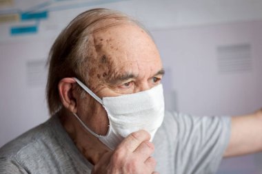 Evde kendini izole eden yaşlı bir adam.