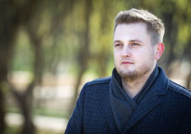 Parkta paltolu bir adamın portresi.