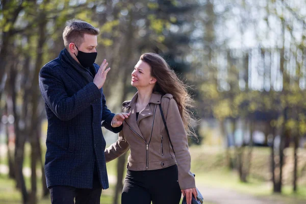 Masked couple walking in the park — Stock Photo, Image